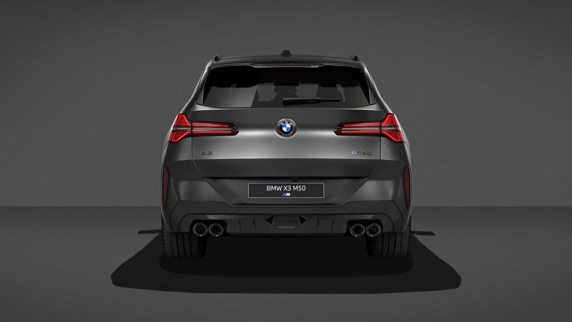 منظر خلفي لسيارة BMW X3 M50 xDrive مع مصابيح خلفية حمراء وأربعة مخارج عادم دائرية.